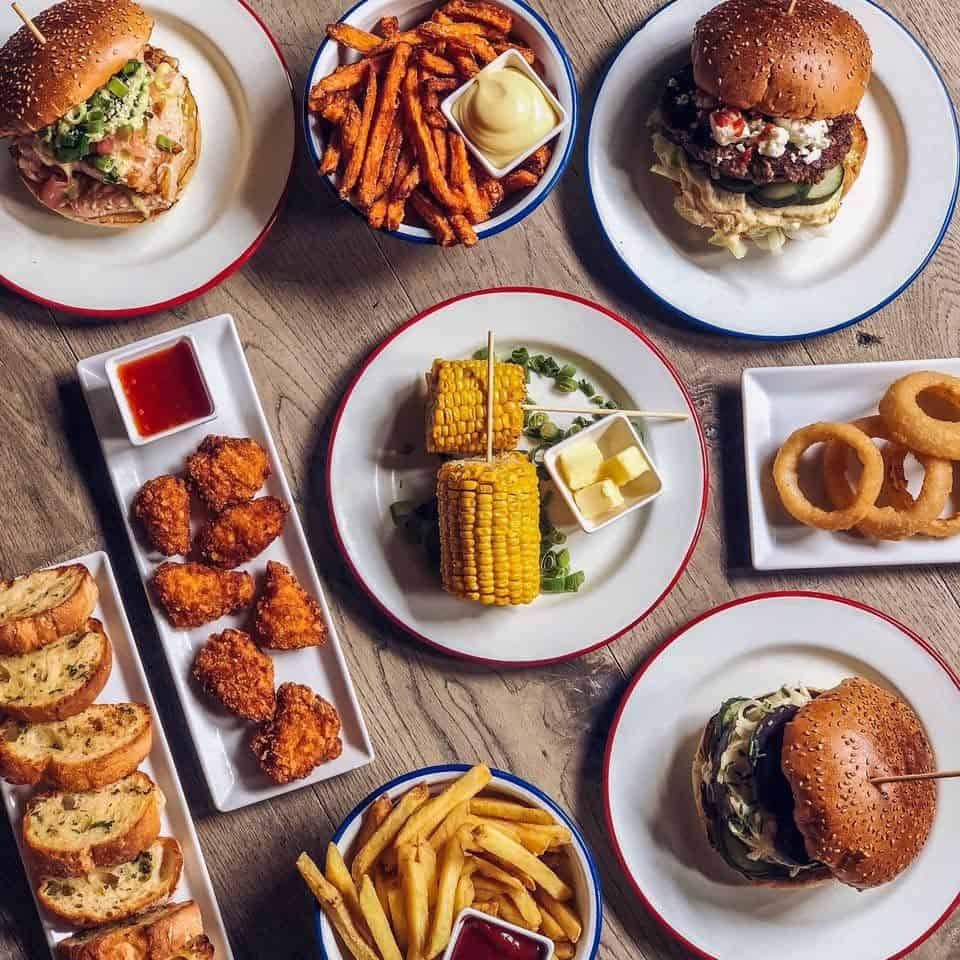 Gezellige tafel vol burgers, frieten en snacks bij De Burgerij in Antwerpen